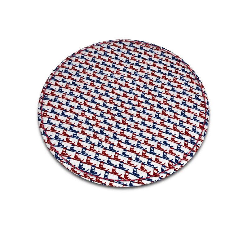 A round leather coaster with red and blue ski boot pattern that's similar to a traditional houndstooth pattern.