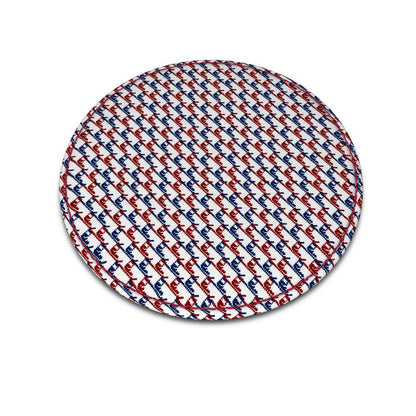 A round leather coaster with a ski boot pattern in red, white and blue.
